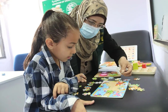 Reham Abdel Karim Matar playing with trainer. (KSrelief)