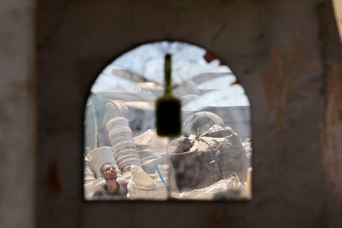 A Palestinian worker prepares plastic for processing to extract fuel in Jabalia on the northern Gaza Strip on August 23, 2022. (AFP)