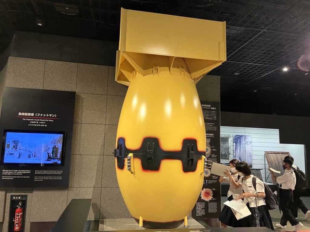 Students take a close look at a replica displayed in the Nagasaki Atomic Bomb Museum of the plutonium bomb codenamed 