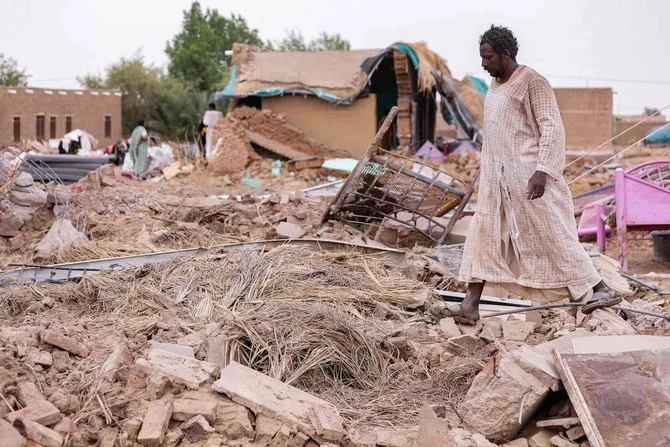A man walks past the remains of a destroyed mudbrick house following floods in the village of Makaylab in Sudan's Nile River State on August 19, 2022. (AFP)