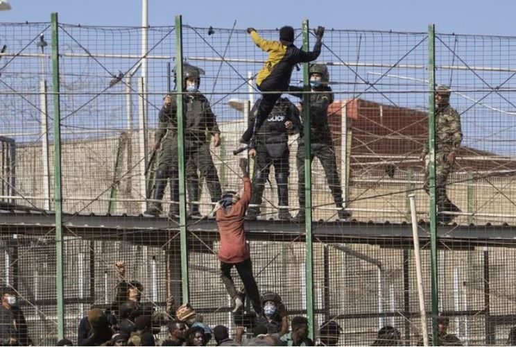 Migrants climb the fences separating the Spanish enclave of Melilla from Morocco on June 24, 2022. (File/AP)
