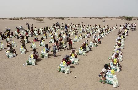 In this file photo taken on July 6, 2022, Yemenis displaced by the conflict receive food aid and supplies to meet their basic needs, at a camp in Hays district in the war-ravaged western province of Hodeida. (AFP)