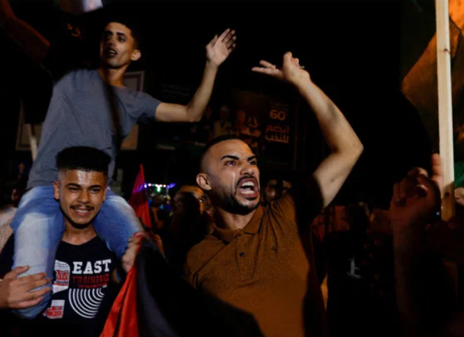 Palestinians celebrate on a street in Gaza City early Monday after a ceasefire between Israeli and Islamic Jihad forces was announced. (REUTERS/Ibraheem Abu Mustafa)