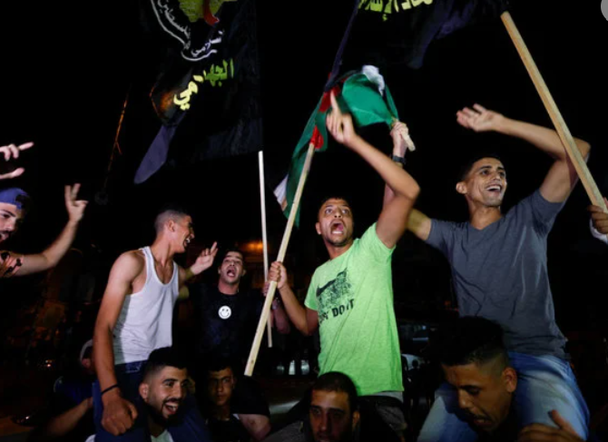 Palestinians celebrate on a street in Gaza City early Monday after a ceasefire between Israeli and Islamic Jihad forces was announced. (REUTERS/Ibraheem Abu Mustafa)