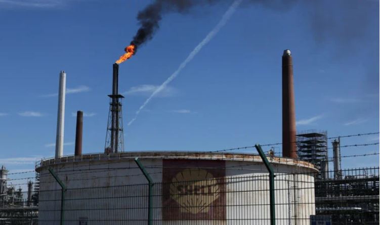 An oil tank of Shell is seen as a pilot flame burns atop a flare stack at the refinery of the Shell Energy and Chemicals Park Rheinland in Godorf near Cologne, Germany, August 3, 2022. (Reuters)