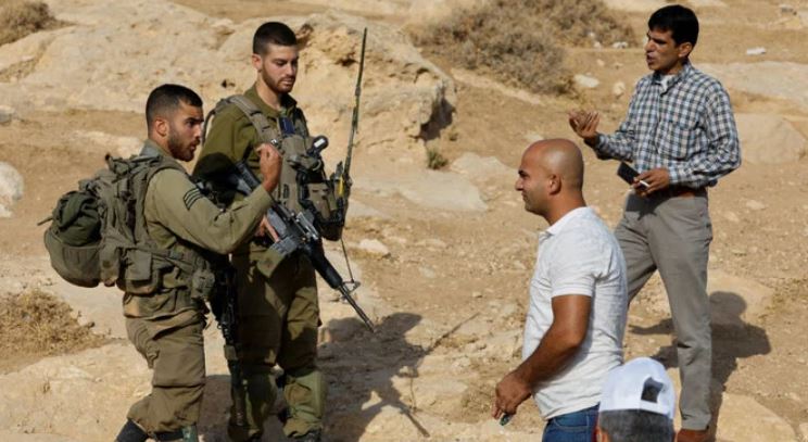 Palestinian teacher argues with an Israeli army soldier on first day of new school year in Masafer Yatta near Hebron, in the Israeli-occupied West Bank, August 29, 2022. (Reuters)