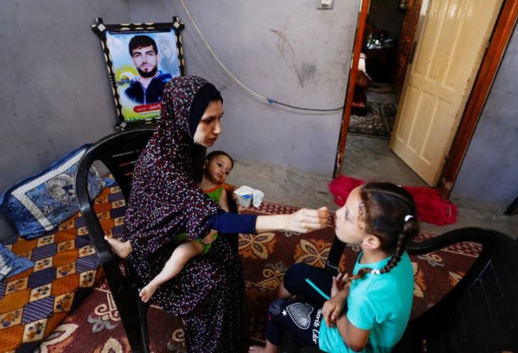 Wife of Shadi Khail, who was killed in the recent Israel-Gaza fighting, feeds her children at her home in Gaza City August 16, 2022. (REUTERS)