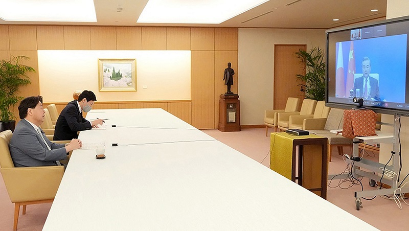 This handout picture taken and provided on May 18, 2022 by the Ministry of Foreign Affairs of Japan via Jiji Press shows Japan's Foreign Minister Yoshimasa Hayashi (left) speaking with China's Foreign Minister Wang Yi (right) via video link in Tokyo. (AFP)