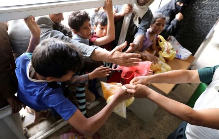 People crowd to get food rations from a charity kitchen in Sanaa, Yemen July 20, 2020. (Reuters)
