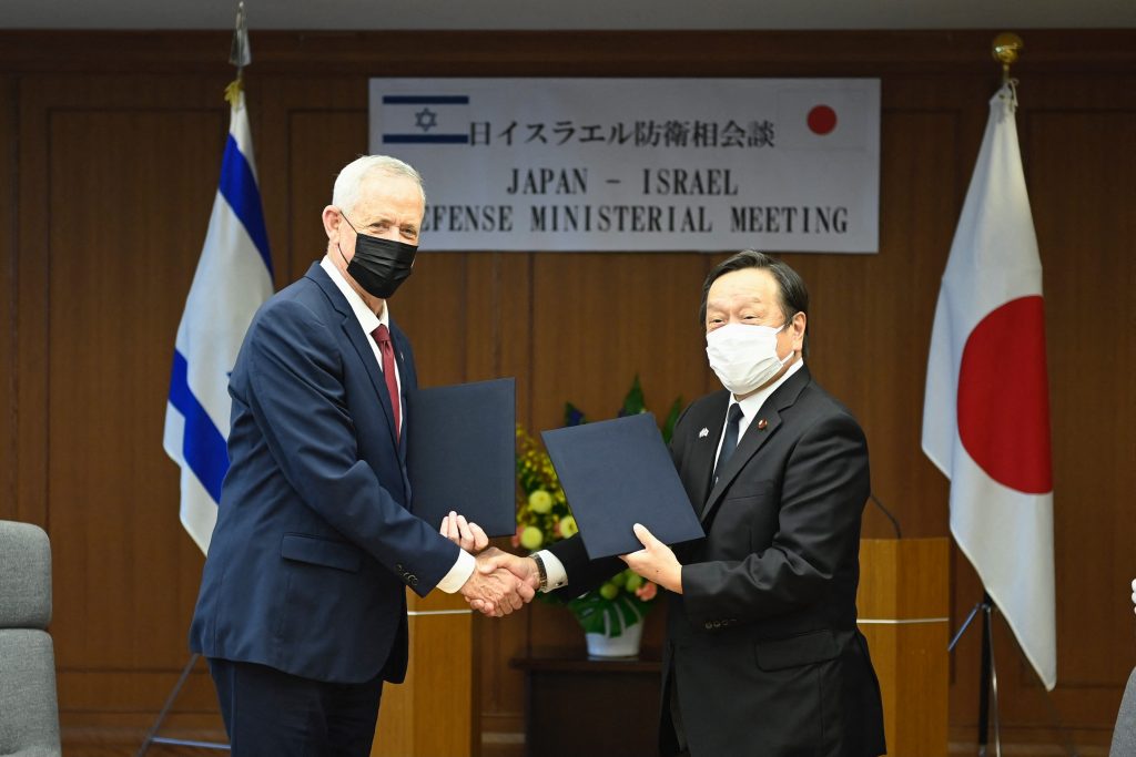 Israeli Defense Minister Benny Gantz (L) and Japan's Defense Minister Yasukazu Hamada (R) shake hands during a signing of Japan-Israel Defense exchange memorandum of understanding after their bilateral Defense meeting in Tokyo on August 30, 2022. (AFP)