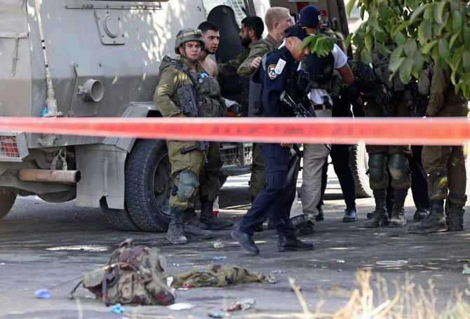 Israeli soldiers gather around an injured soldier at the scene of a reported stabbing attack in Hebron in the Israeli occupied West Bank, on September 2, 2022. (AFP)