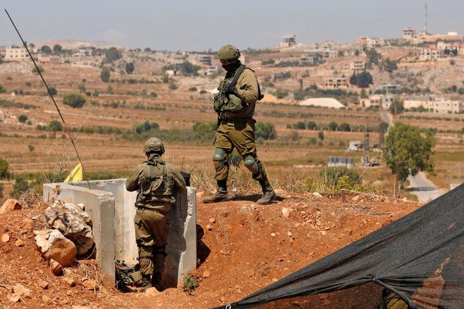 Israeli soldiers stand position in northern Israel along the border with Lebanon near a flag of the Lebanese Shiite movement Hezbollah, on September 12, 2022. (File/AFP)