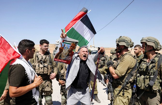 Palestinian, Israeli and international activists take part in a demonstration against settlements, near the village of al-Tweine, south of Hebron city in the occupied West Bank on September 17, 2022. (AFP)