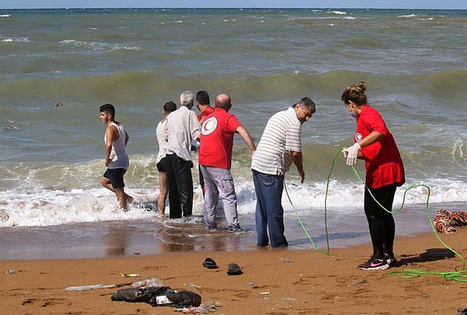 A handout picture released by the Syrian Red Crescent on Friday shows rescuers pulling out the body of a drowning victim on the coast of Syria’s southern port City of Tartus, after a boat transporting migrants from Lebanon sank off the Syrian coast. (AFP)