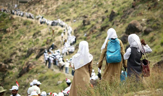 Yemeni volunteers form a human chain to pass food aid to mountainous towns on the outskirts of the country’s third-city of Taiz. (AFP/File)