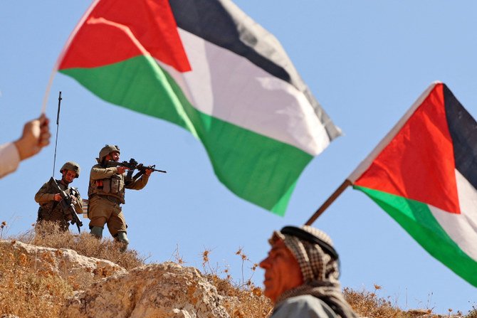 Palestinians demonstrate near Israeli forces against the establishment of Israeli outposts in Beit Dajan on Sept. 9, 2022. (AFP)
