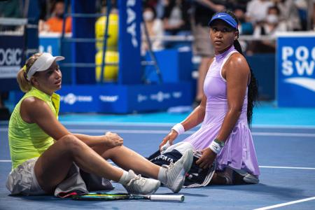 Naomi Osaka of Japan (right) assists Daria Saville of Australia after she injured herself during their women's singles match on day two of the Pan Pacific Open tennis tournament in Tokyo on September 20, 2022. (AFP)