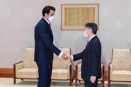 This handout picture taken and released on September 28, 2022 and provided by the Imperial Household Agency of Japan shows Qatar’s Emir Sheikh Tamim bin Hamad al-Thani (left) shaking hands with Japan's Emperor Naruhito during their meeting at the Imperial Palace in Tokyo. (AFP)