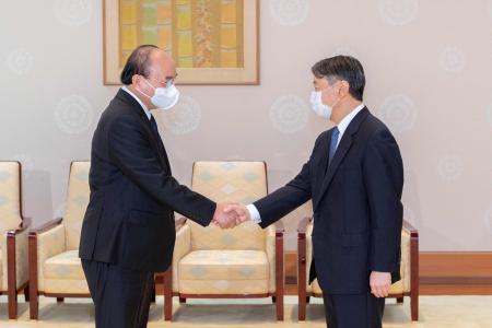 This handout picture taken and released on September 28, 2022 and provided by the Imperial Household Agency of Japan shows Vietnam's President Nguyen Xuan Phuc (left) shaking hands with Japan's Emperor Naruhito during their meeting at the Imperial Palace in Tokyo. (AFP)