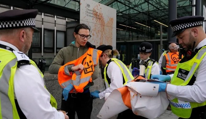 Just Stop Oil protesters are arrested after tomato soup was thrown over a government sign, London, Oct. 17, 2022. (AP Photo)