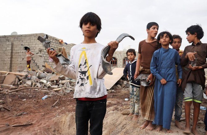 A boy holds shrapnel at the site of a Houthi missile attack in Marib, Yemen, Oct. 3, 2021. (Reuters)