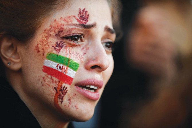 A demonstrator with the Iranian flag painted on her face attends a rally in Paris in support of anti-regime protesters. (AFP)
