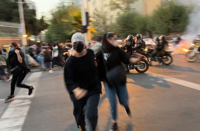 Young women run away from anti-riot police during a protest over the death in custody of 22-year-old student Mahsa Amini, Tehran, Iran, Sept. 19, 2022. (AP Photo)