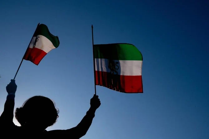 Demonstrators carry Iranian flags while marching during the