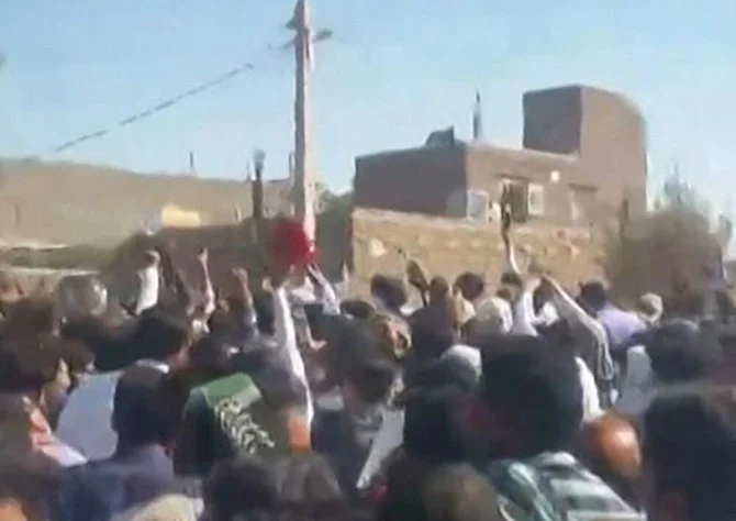 This grab from a UGC video posted on Friday, shows demonstrators gesturing as they march on a street in the southeastern Iranian city of Zahedan. (AFP)