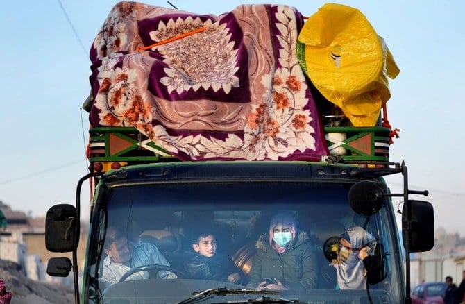 A Syrian refugee family sits inside a truck as they wait to cross the border to Syria, Arsal, Lebanon, Oct. 26, 2022. (AP Photo)