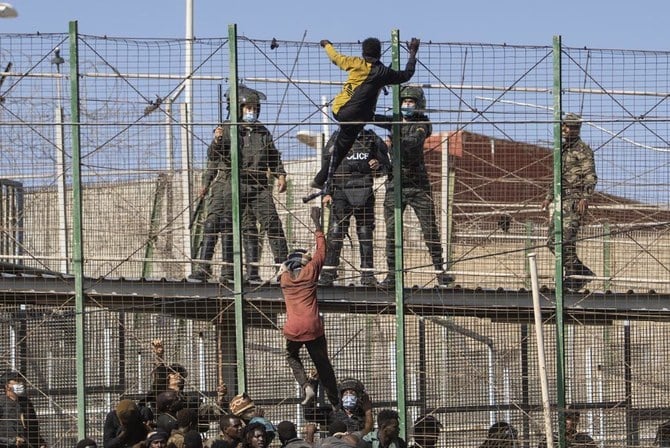 Migrants climb the fences separating the Spanish enclave of Melilla from Morocco on June 24, 2022. (File/AP)