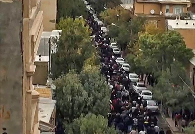 This image grab from a UGC video posted on October 27, 2022, shows protesters marching on a street in Iran's Kurdish city of Mahabad as demonstrations re-erupt a day after a protester was killed in a rally commemorating the 40th day since Mahsa Amini's death. (AFP)