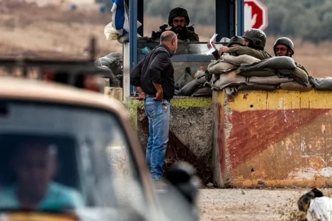 A Palestinian hands his documents to an Israeli soldier manning a checkpoint between the Palestinian city of Nablus and the village of Beit Furik in the occupied West Bank. (AFP/File)