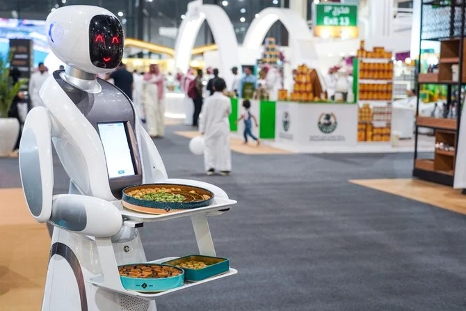 Robots are on hand serving bottles of water and Arabic sweets. (AN photo/Huda Bashatah)