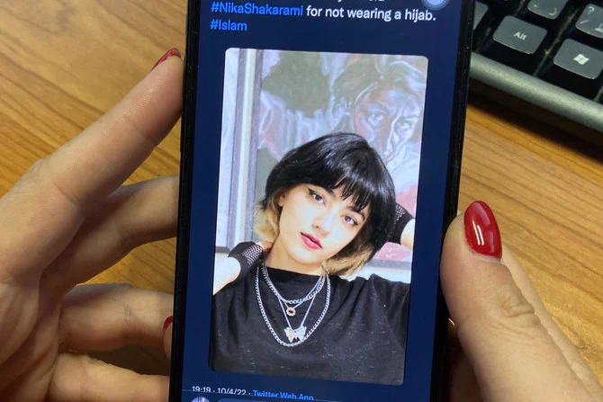 A woman looks at the profile picture of Iranian teenager, Nika Shakrami, who was reportedly killed recently during protests in Iran over the death in police custody of 22-year-old Mahsa Amini, on Thursday. (AFP)