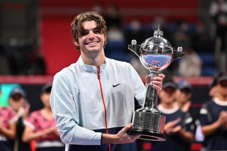 Taylor Fritz of the US poses with the trophy as he celebrates his victory over compatriot Frances Tiafoe during the awards ceremony of the men’s singles final match at the Japan Open tennis tournament in Tokyo on October 9, 2022. (AFP)