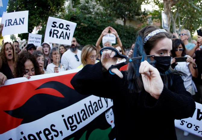 A woman cuts her hair during a protest against the Islamic regime of Iran and the death of Mahsa Amini in front of the Iranian Embassy in Madrid, Spain October 6, 2022. (File/Reuters)