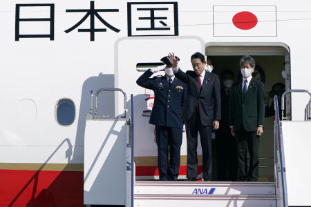 Japanese Prime Minister Fumio Kishida, center, waves as his departure for Australia, at Haneda international airport in Tokyo, Friday, Oct. 21, 2022. (Kyodo News via AP)