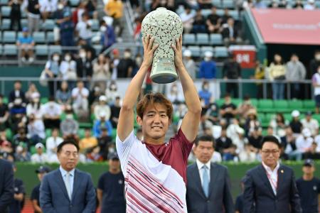 Yoshihito Nishioka of Japan poses with the trophy after winning the men’s singles final match against Denis Shapovalov of Canada at the Korea Open Tennis Championships in Seoul on October 2, 2022. (AFP)
