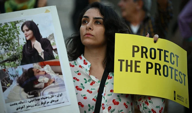 A protester holds pictures of Mahsa Amini during a demonstration in solidarity with Iranian women in Rome. (AFP)