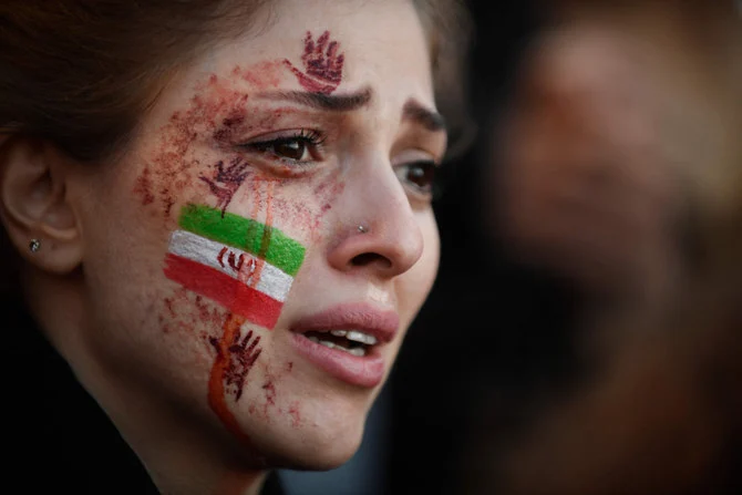 A demonstrator with an Iranian flag on her face attends a rally in Paris on Oct. 9, 2022, in support of Iranian protests. (AFP)