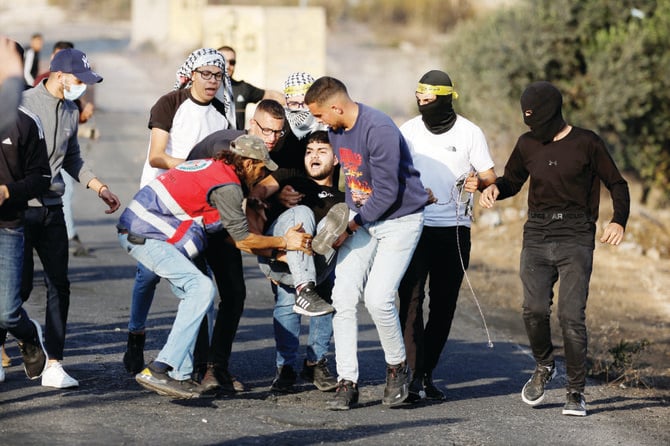 Palestinians help a fellow activist after he was injured on Saturday by a real bullet during clashes with Israeli forces near Ramallah in the Israeli-occupied West Bank. (Reuters)