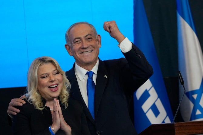 Former Israeli Prime Minister and the head of Likud party, Benjamin Netanyahu and his wife Sara gesture after first exit poll results for the Israeli Parliamentary election at his party's headquarters in Jerusalem. (AP)