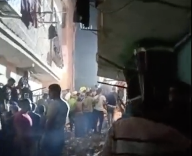 Egyptian rescue operators and civilians search for survivors after a five-floor building collapsed in Imbaba on Tuesday evening. (Screengrab)