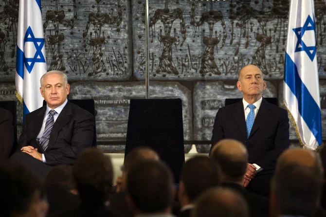 The court ruled that Ehud Olmert’s, right, portrayal of Benjamin Netanyahu, his wife Sara and son Yair had exposed them to hate, ridicule or degradation.’ (AP)