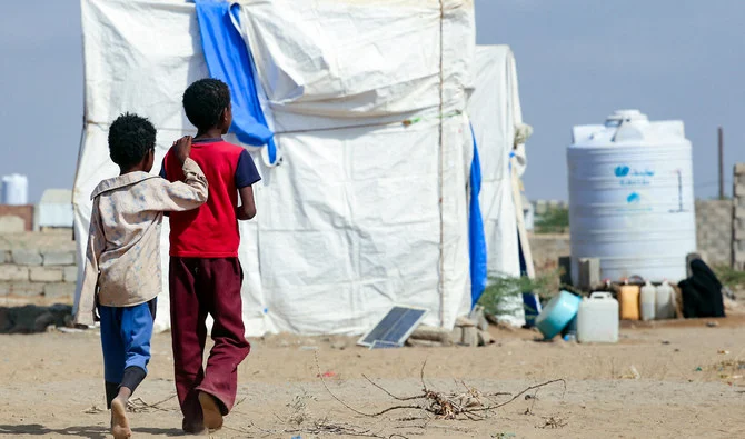 Children walk in front of tents at a camp for displaced Yemenis in Yemen's western province of Hodeida, on February 5, 2022. (AFP/File)