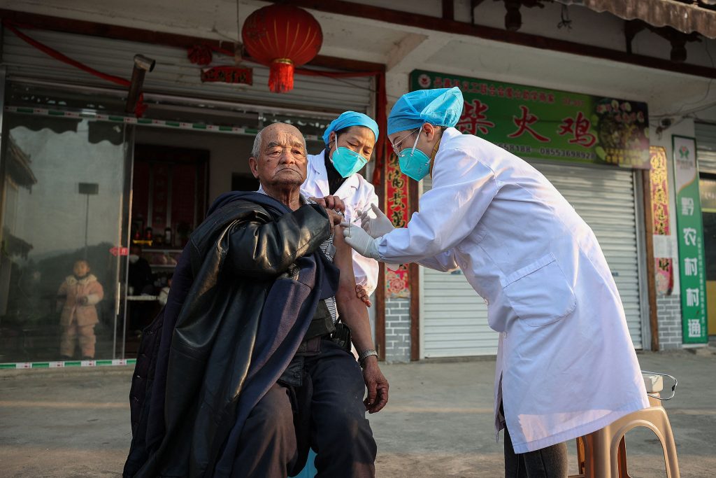 A resident (L) receives a Covid-19 vaccine in Danzhai county, Qiandongnan Miao and Dong Autonomous Prefecture, in China's southwestern Guizhou province, as medical workers vaccinate people who can't go out conveniently from their homes. (AFP)