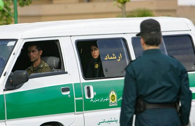 Iranian policewoman looks on from the back of a police vehicle before the start of a crackdown to enforce Islamic dress code in the capital Tehran. (File/AFP)