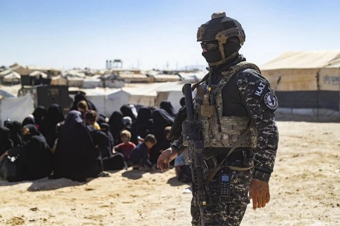 A member of the Syrian Kurdish Asayish security forces stands guard during an inspection of tents at Al-Hol camp, which holds relatives of suspected Daesh fighters. (AFP)