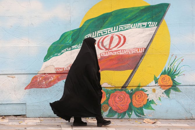 Woman walks after morality police reportedly shut down in street in Tehran. (File/Reuters)